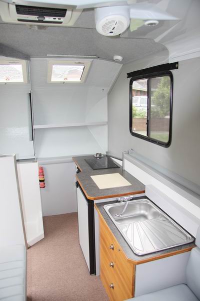 Vanaf het bed 
Het keuken gedeelte en ladekast.
De spoelbak heeft warm en koud water. 
Op de plank tegen de achterwand hebben we de 23.5" TV vast gemonteerd en met rubber eschermd als het dak inschuift tegen rammelen. Dan hebben we niet meer een losse TV als de caravan is ingeschoven.